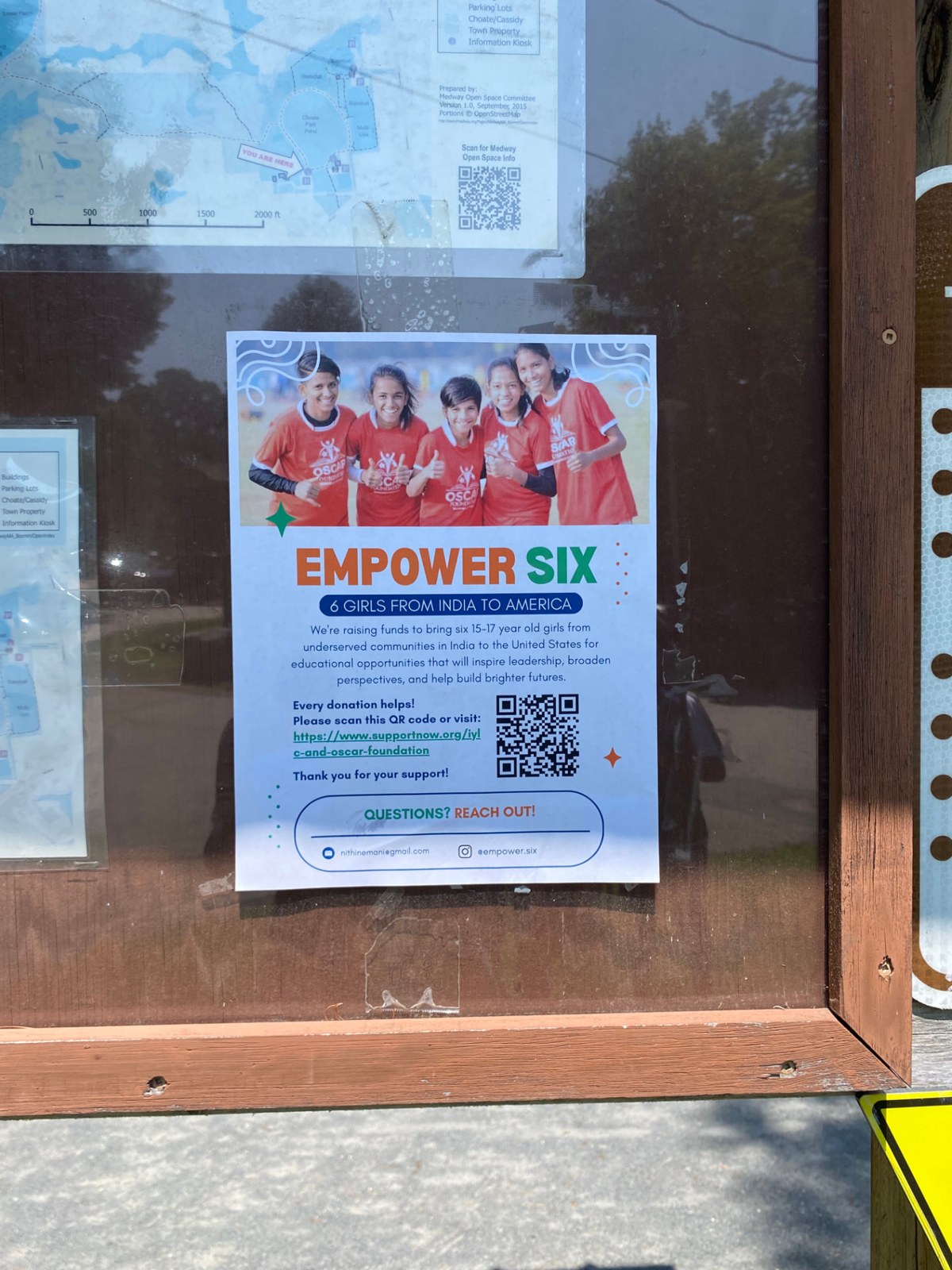 An 'Empower Six' OSCAR Foundation campaign flyer posted in a community information kiosk