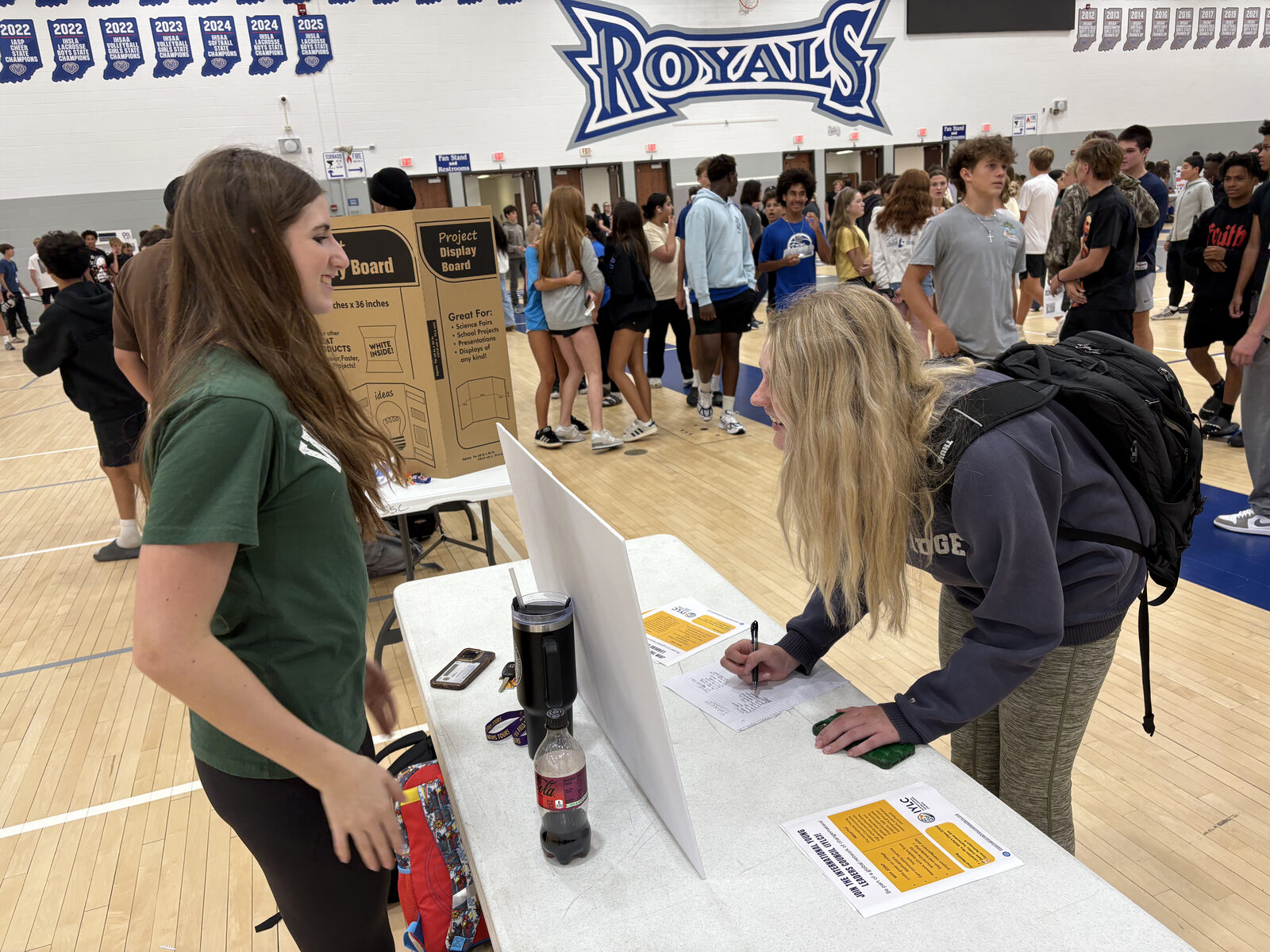 An IYLC student signing up a classmate at a school club fair table